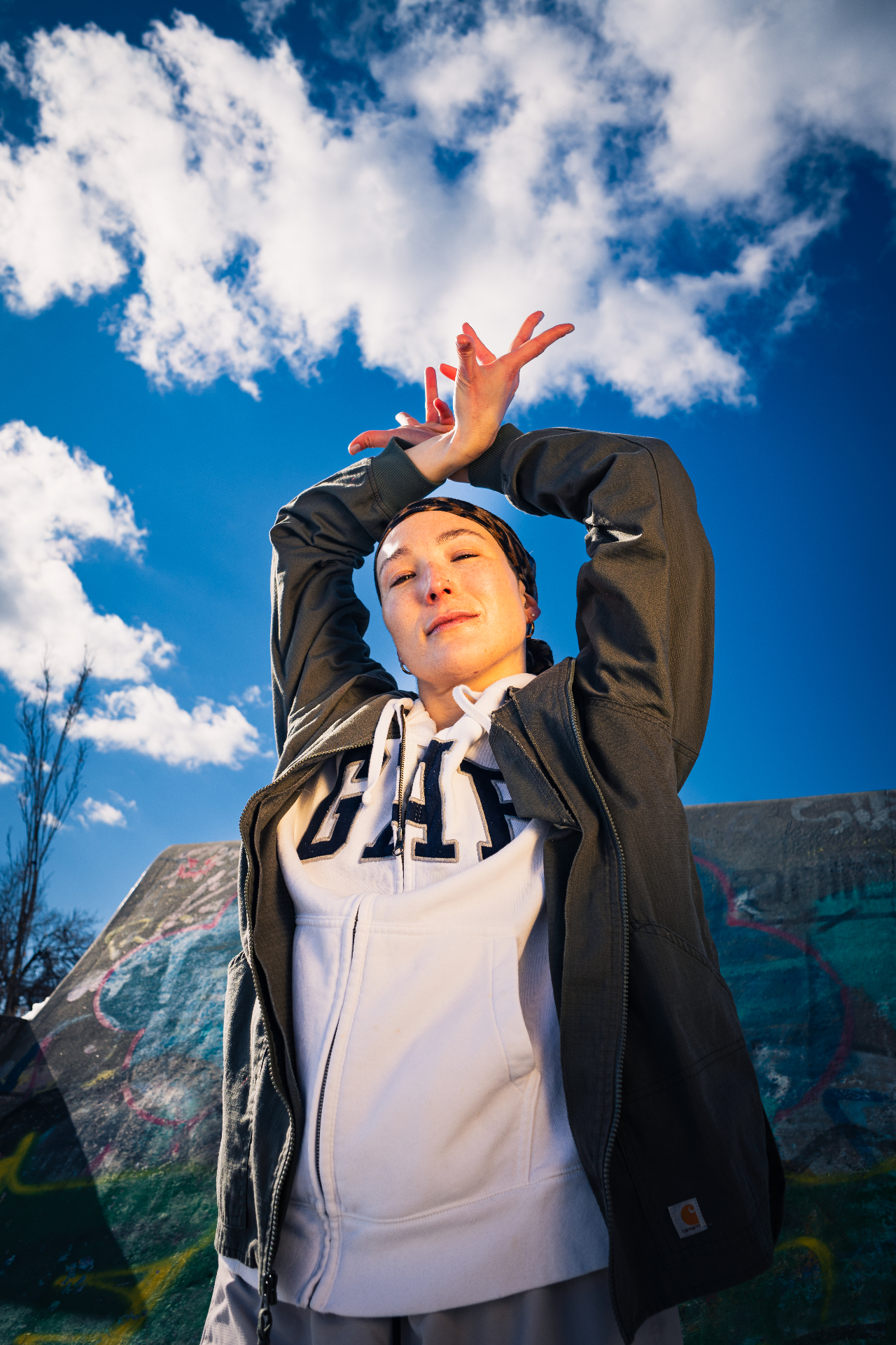 Dancer framed against a bright blue sky, expressing movement and confidence.