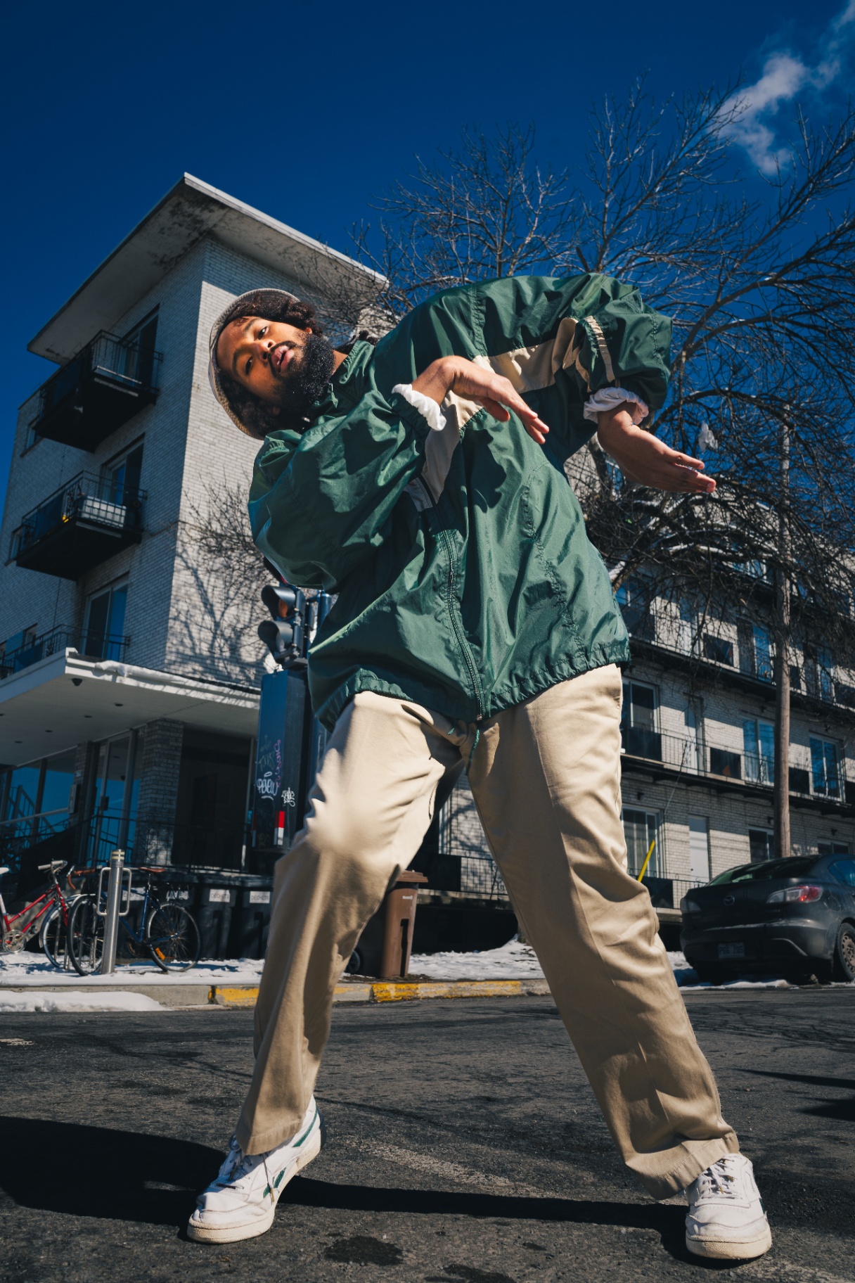 Dancer mid-movement on a Mile End street in winter light.