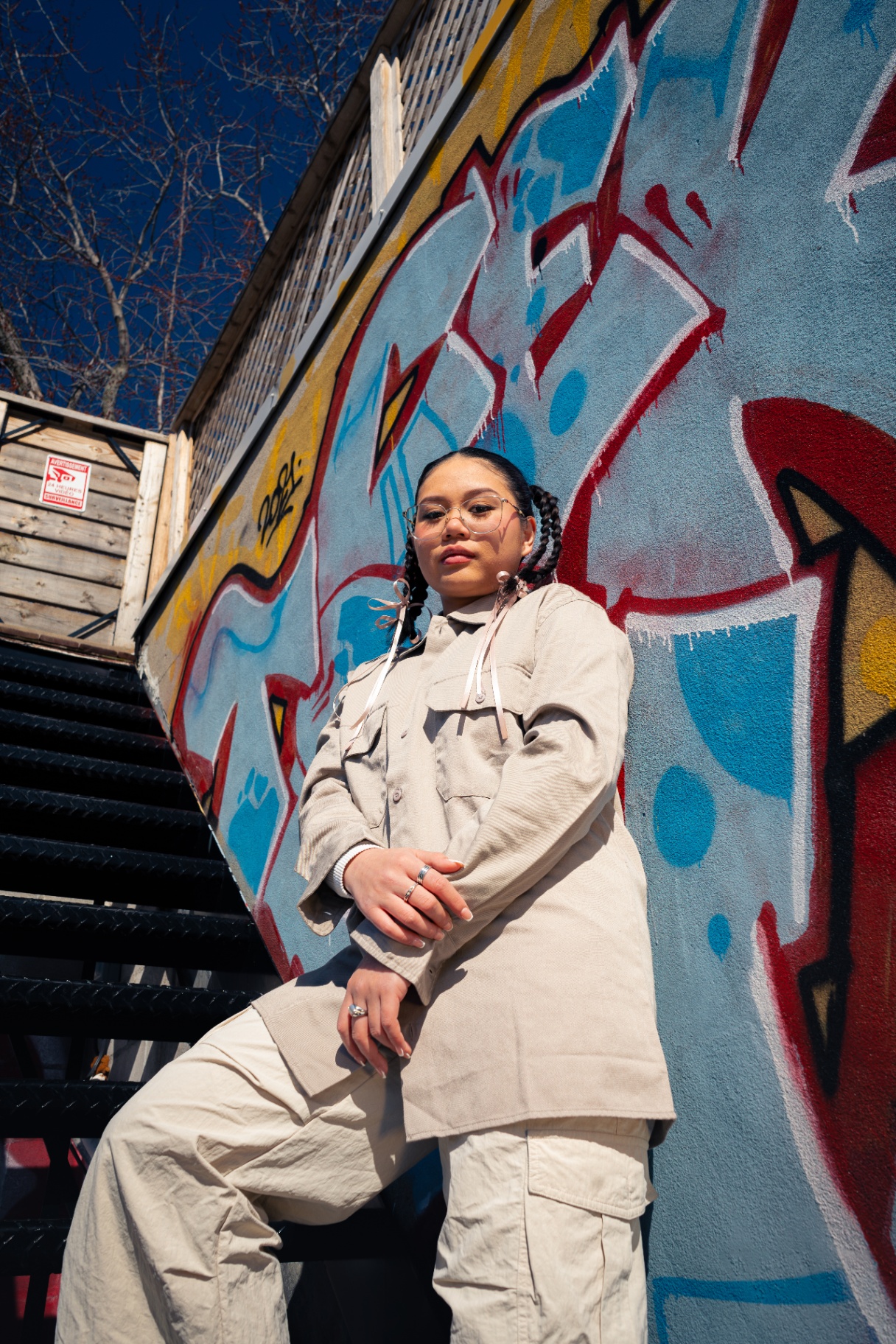 Community member posing on stairs in front of vibrant Montreal graffiti.